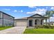 Charming single-Gathering home featuring a manicured lawn, two-car garage, and covered front porch at 13730 Evergreen Valley Dr, Riverview, FL 33578