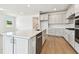 Bright kitchen featuring stainless appliances, white cabinets, an island and wood floors at 13730 Evergreen Valley Dr, Riverview, FL 33578