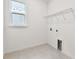 A laundry room with hookups, window, tile floor, and shelving at 13730 Evergreen Valley Dr, Riverview, FL 33578