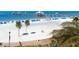 Picturesque beach scene with white sand, blue umbrellas, and a pier in the distance at 241 Skiff Pt # 4, Clearwater Beach, FL 33767
