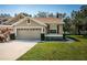 Tan two-story house with a two-car garage and landscaped lawn at 656 Spring Lake W Cir, Tarpon Springs, FL 34688