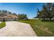 Two-story house with tan exterior, two-car garage and large backyard at 656 Spring Lake W Cir, Tarpon Springs, FL 34688