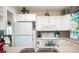 White kitchen with stainless steel appliances and tile floors at 216 Gloucester Blvd # 216, Sun City Center, FL 33573