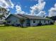 Rear view of light blue single-story home with a spacious lawn at 216 Gloucester Blvd # 216, Sun City Center, FL 33573