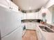 Clean, white kitchen with ample cabinetry and tile floors at 216 Gloucester Blvd # 216, Sun City Center, FL 33573