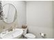 Small bathroom with white sink, toilet, and round mirror at 10012 Corso Milano Dr, Tampa, FL 33625