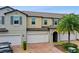 Modern two-story townhouse with attached garage and palm tree at 10012 Corso Milano Dr, Tampa, FL 33625