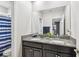 Bathroom with double vanity, granite countertop, and blue striped shower curtain at 10012 Corso Milano Dr, Tampa, FL 33625