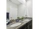 Bathroom with double vanity, granite countertop, and large mirror at 10012 Corso Milano Dr, Tampa, FL 33625