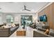 Bright living room with comfortable seating, a large TV, and sliding glass doors leading to the backyard at 10012 Corso Milano Dr, Tampa, FL 33625