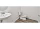 Simple bathroom with a toilet and sink, featuring wood-look flooring at 13728 Evergreen Valley Dr, Riverview, FL 33578