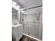 Updated bathroom with a walk-in shower and marble-look tile at 10007 N 22Nd St, Tampa, FL 33612