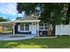 Charming one-story home with a navy blue exterior and landscaped yard at 10007 N 22Nd St, Tampa, FL 33612
