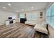 Bright living room featuring a sectional sofa, fireplace, and wood-look flooring at 10007 N 22Nd St, Tampa, FL 33612