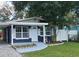Charming house with a navy blue exterior, landscaped yard, and a carport at 10007 N 22Nd St, Tampa, FL 33612