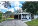 Front view of a renovated home with a carport and well-manicured lawn at 10007 N 22Nd St, Tampa, FL 33612