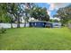 Spacious backyard with lush green grass, mature trees, and a privacy fence at 10007 N 22Nd St, Tampa, FL 33612