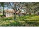 Large backyard with mature trees and grassy area at 656 Spring Lake W Cir, Tarpon Springs, FL 34688