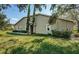 House exterior with side yard and landscaping at 656 Spring Lake W Cir, Tarpon Springs, FL 34688