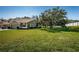 Tan house exterior with two-car garage and landscaping at 656 Spring Lake W Cir, Tarpon Springs, FL 34688