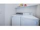Bright laundry room, complete with washer and dryer, and shelving for storage at 656 Spring Lake W Cir, Tarpon Springs, FL 34688
