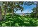 Serene lakefront view with private dock, lush landscaping, and mature trees at 656 Spring Lake W Cir, Tarpon Springs, FL 34688