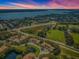 Community overview featuring houses, a pond, and a nearby lake at 656 Spring Lake W Cir, Tarpon Springs, FL 34688
