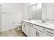 Modern bathroom featuring double sinks, white cabinetry, and neutral-toned tile flooring at 13720 Brookside Haven St, Riverview, FL 33578