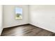 Bedroom featuring wood floors, base trim and a view of the home across the street at 13720 Brookside Haven St, Riverview, FL 33578