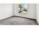 Bright bedroom with gray carpet and a window view of a palm tree and neighborhood at 13720 Brookside Haven St, Riverview, FL 33578