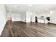 Spacious empty room with wood floors featuring a view of the kitchen at 13720 Brookside Haven St, Riverview, FL 33578