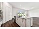Kitchen island with white cabinets, stainless steel sink, and black hardware at 13720 Brookside Haven St, Riverview, FL 33578