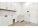 Efficient laundry room with sink, storage, and tile flooring at 13720 Brookside Haven St, Riverview, FL 33578