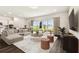Open-concept living room with dark floors, neutral furnishings, and sliding doors to the backyard at 13720 Brookside Haven St, Riverview, FL 33578