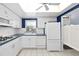 White kitchen with blue accents, featuring a refrigerator and dishwasher at 1868 Shore S Dr # 207, South Pasadena, FL 33707