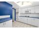 White kitchen with blue backsplash, gas range, microwave, and ample cabinetry at 1868 Shore S Dr # 207, South Pasadena, FL 33707