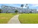 Condo building exterior with lush green lawn and walkway at 1868 Shore S Dr # 207, South Pasadena, FL 33707
