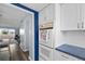 White kitchen with a double oven and blue accent wall, offering ample storage at 1868 Shore S Dr # 207, South Pasadena, FL 33707