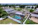 Aerial view of a private backyard featuring a screened-in pool, lush landscaping and white privacy fence at 2040 N Highland Ave, Clearwater, FL 33755