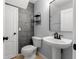 Compact bathroom with modern fixtures, gray wall tiles and pedestal sink at 214 Cape Harbour Loop # 105, Bradenton, FL 34212