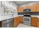 Well-lit kitchen featuring wood cabinets, stainless steel appliances and tiled flooring at 214 Cape Harbour Loop # 105, Bradenton, FL 34212