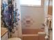 Bathroom with pink tile, shower/tub combo, and patterned curtain at 2392 Indigo Dr, Clearwater, FL 33763