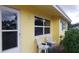 Front porch with yellow exterior and two chairs at 2392 Indigo Dr, Clearwater, FL 33763