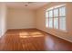 Empty bedroom with wood-look flooring and a large window with white shutters at 8303 Torrington Ave, Tampa, FL 33647