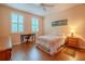 Bedroom with wood-look flooring, plantation shutters, and a wooden bedframe and dresser at 8303 Torrington Ave, Tampa, FL 33647