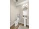 Simple and clean bathroom with pedestal sink, toilet, and arched mirror at 1407 7Th N Ave, St Petersburg, FL 33705
