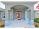 Covered entryway with coral door and arched detail at 2203 W Del Webb Blvd, Sun City Center, FL 33573