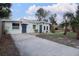 Charming single-story home featuring a private driveway, palm trees and a cozy front patio at 2600 1St St, Indian Rocks Beach, FL 33785