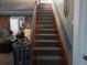 Gray carpeted staircase with wooden handrail at 2255 Trelain S Dr, St Petersburg, FL 33712