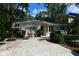 Front view of a charming light-yellow house with a teal roof and blue pots at 785 5Th S St, Safety Harbor, FL 34695